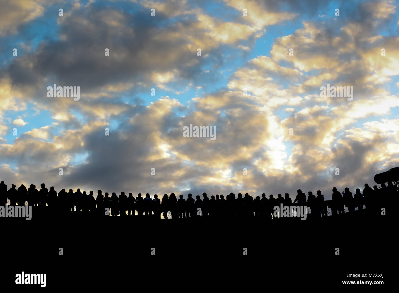 Gruppo di persone diverse sagome in piedi e guardando verso la luce. Piacere dopo aver completato il pellegrinaggio a Lourdes. Foto Stock