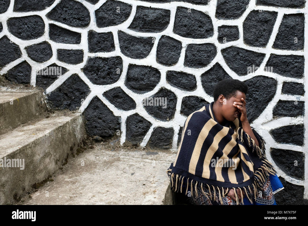 Ruanda: uomo che prega sui gradini della Bigogwe Kanzenze del memorial sito (quasi 9.000 vittime) nel distretto di Rubavu. Vicino a un accampamento militare, un genoci Foto Stock