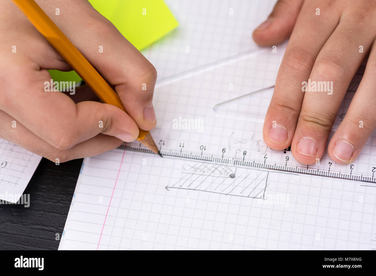 Concetto di matematica. Scolaro mani con righello disegno su carta bianca. Foto Stock