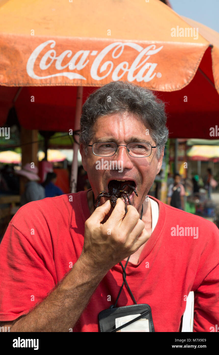 Uomo di mangiare una tarantola ragno, Skuon mercato insetto o spider mercato, Skuon, Cambogia, Asia Foto Stock