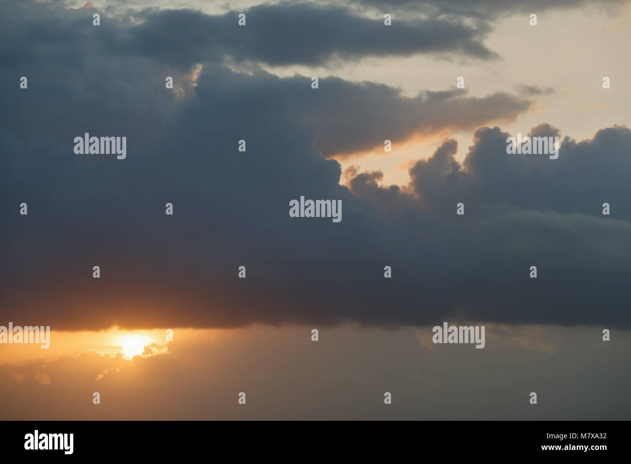 Cielo nuvoloso al tramonto con il sole nascosto da nuvole Foto Stock