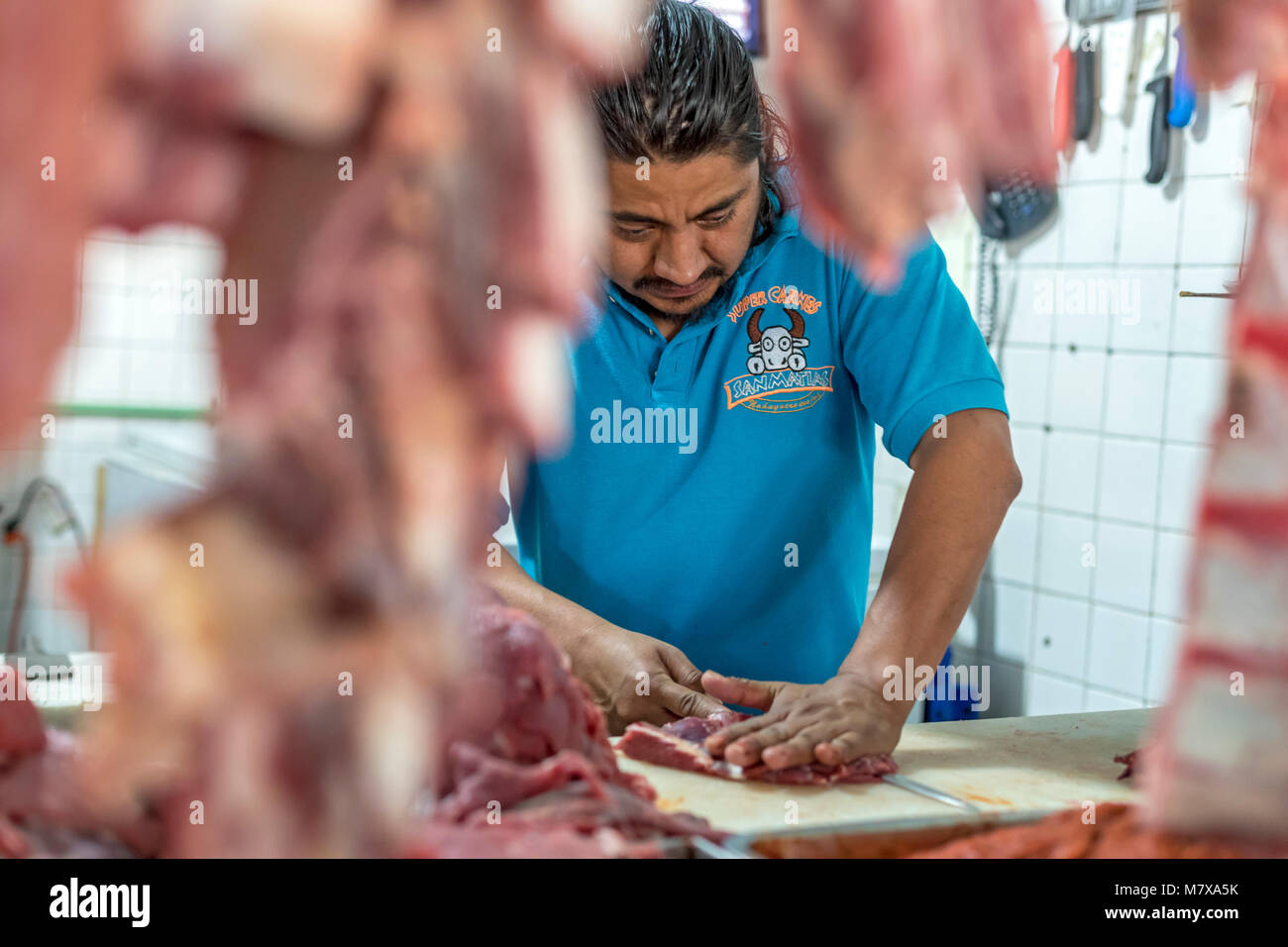 Oaxaca, Oaxaca, Messico - un lavoratore tagli carne al Mercado Zonal Las Flores, un mercato di prossimità in Las Flores quartiere. Foto Stock
