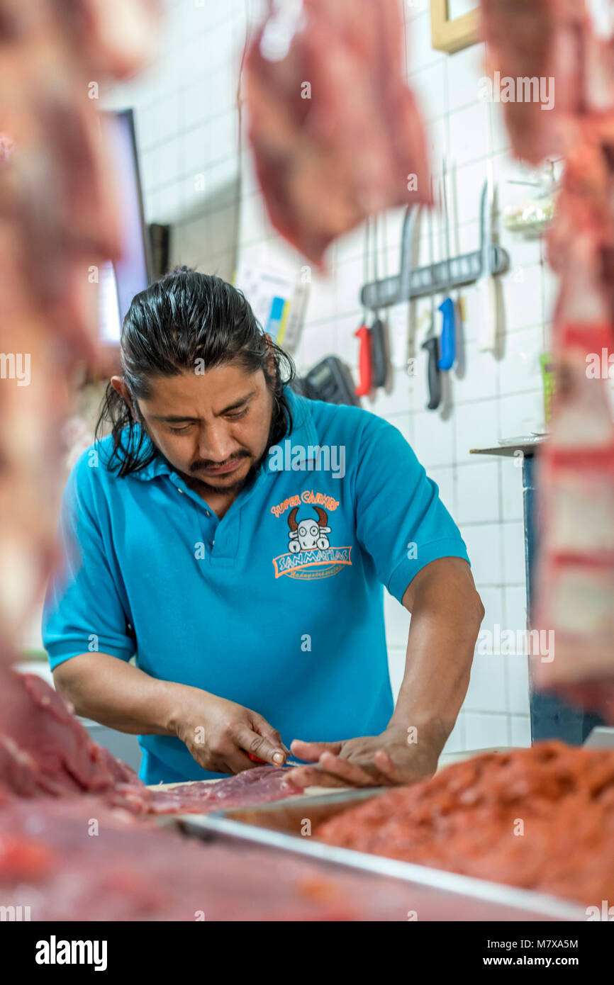 Oaxaca, Oaxaca, Messico - un lavoratore tagli carne al Mercado Zonal Las Flores, un mercato di prossimità in Las Flores quartiere. Foto Stock