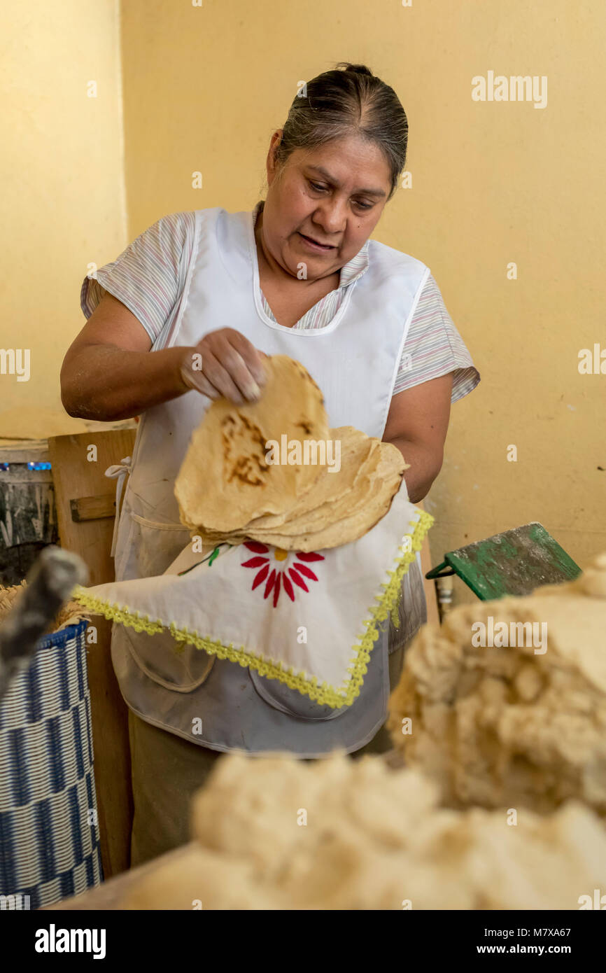 Oaxaca, Oaxaca, Messico - Gloria Hernandez Angeles conta tortillas per un cliente presso il suo negozio in Mercado Zonal Las Flores, un mercato di prossimità i Foto Stock