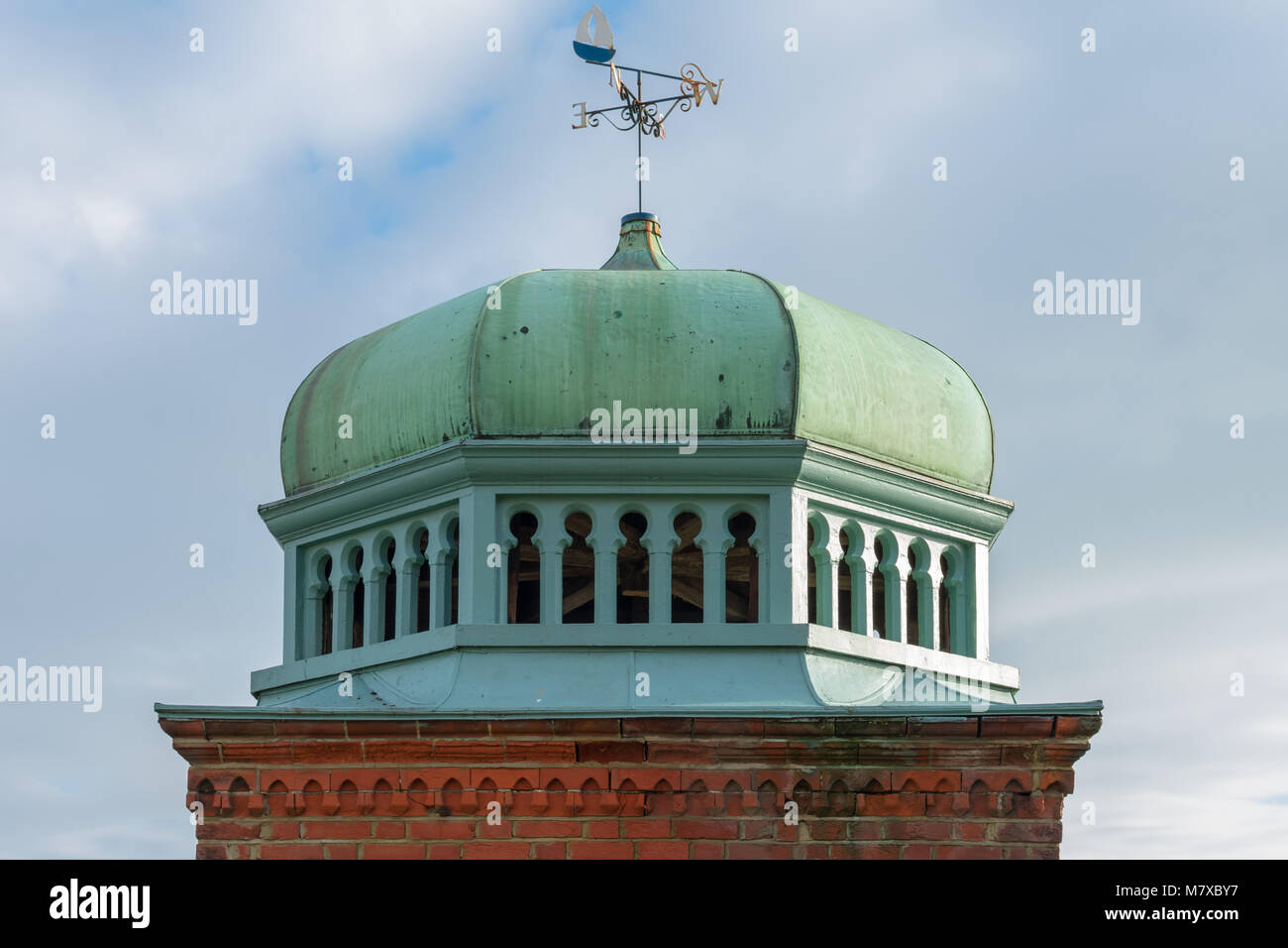 Il rame cupola verde a Bexhill-on-Sea su una base in muratura con un weathervane in cima, fotografato nella primavera del sole. Architettura di Mughal. Foto Stock