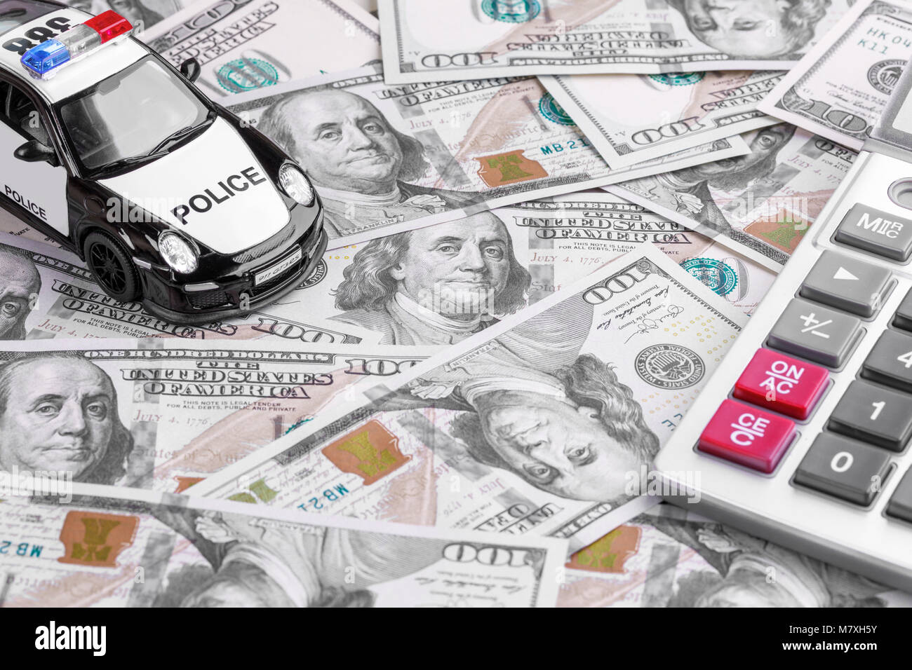 Close-up di un'auto della polizia modello con calcolatrice sul dollaro note Foto Stock