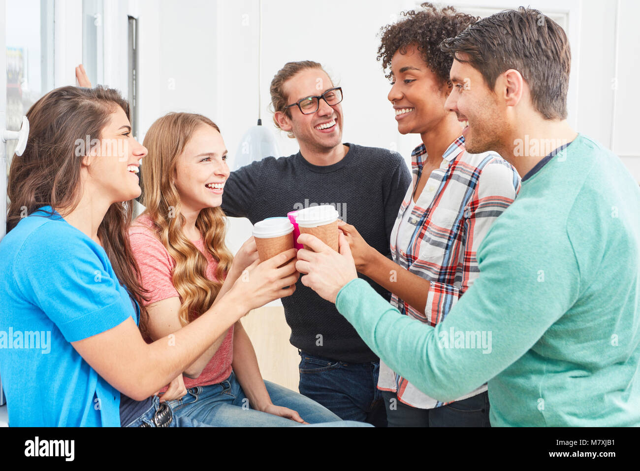 Gli studenti come i colleghi in fase di start-up team bere il caffè insieme e celebrare Foto Stock