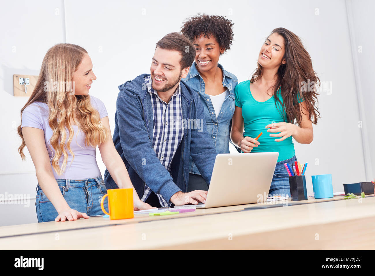 Studenti di sesso femminile e consulenti insieme studio portatile al computer di ufficio Foto Stock