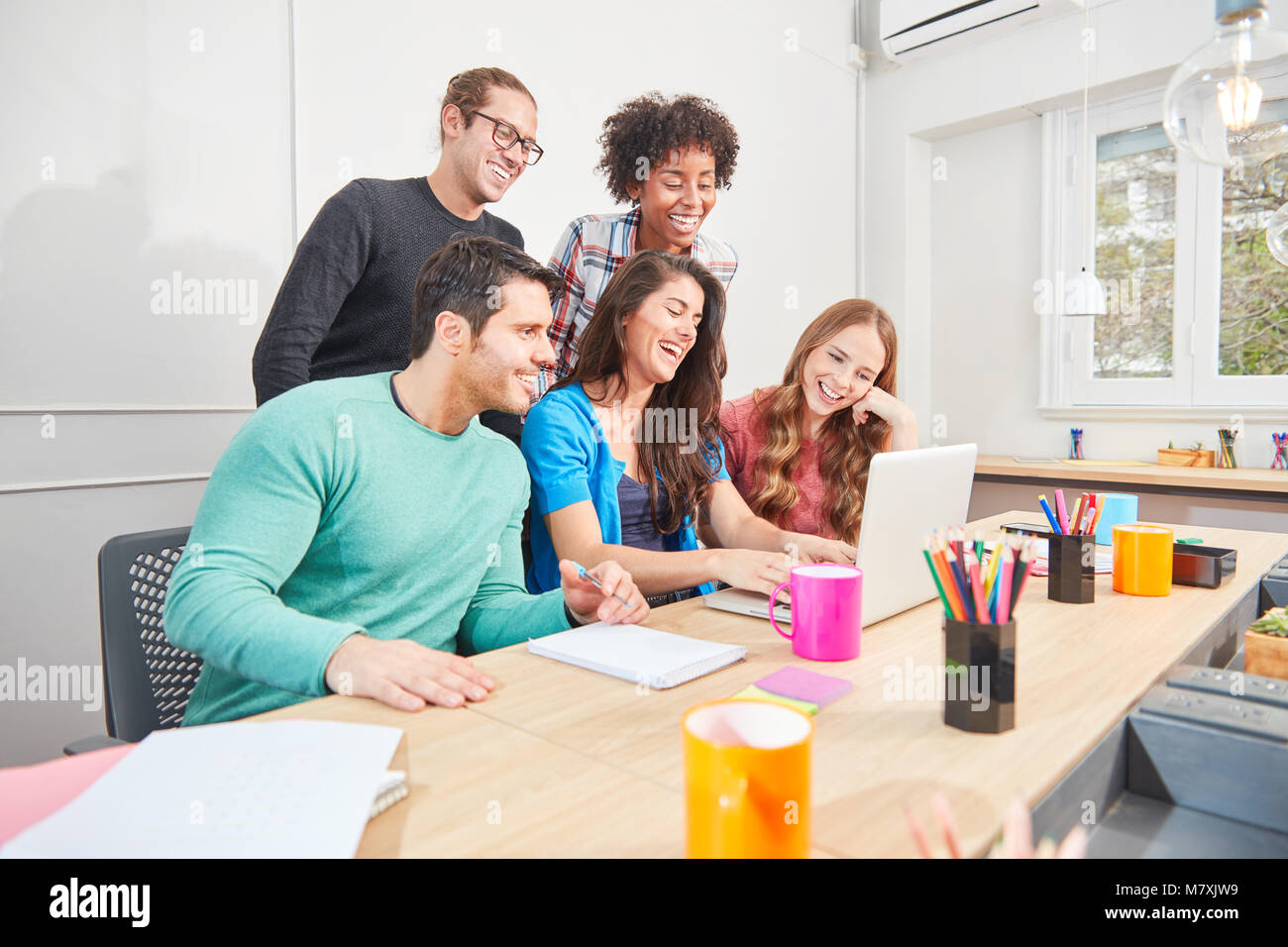 Giovani studenti da internet start-up sul computer portatile si divertono con i social media Foto Stock