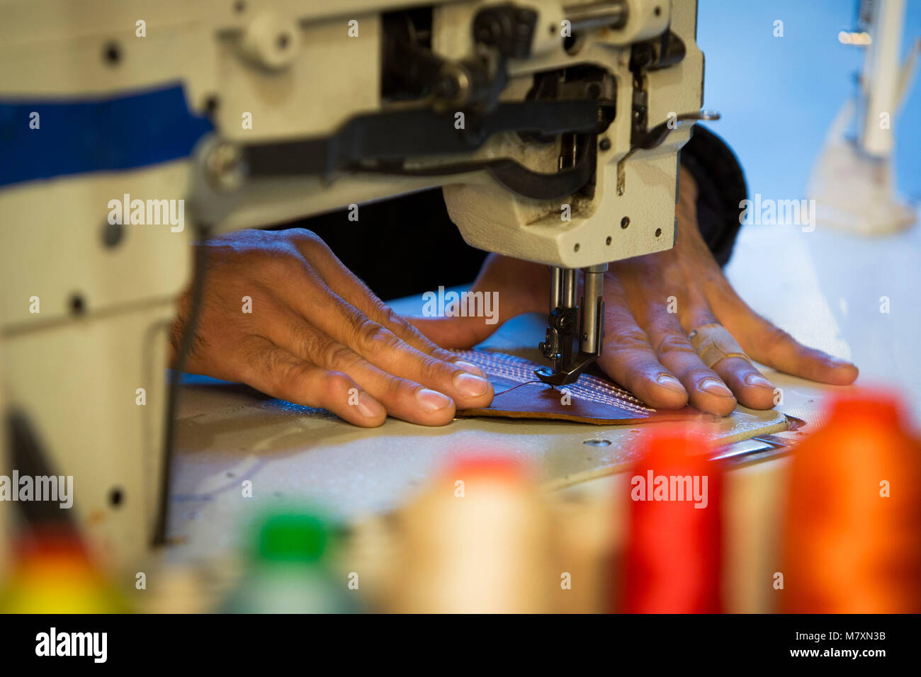 Artigiano lavoratore in pelle facendo una cinghia. Foto Stock