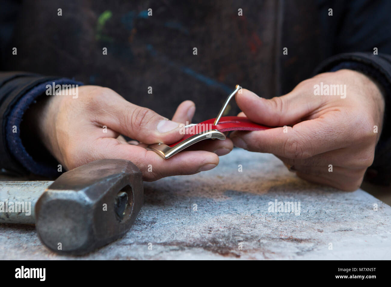 Artigiano lavoratore in pelle facendo una cinghia. Foto Stock
