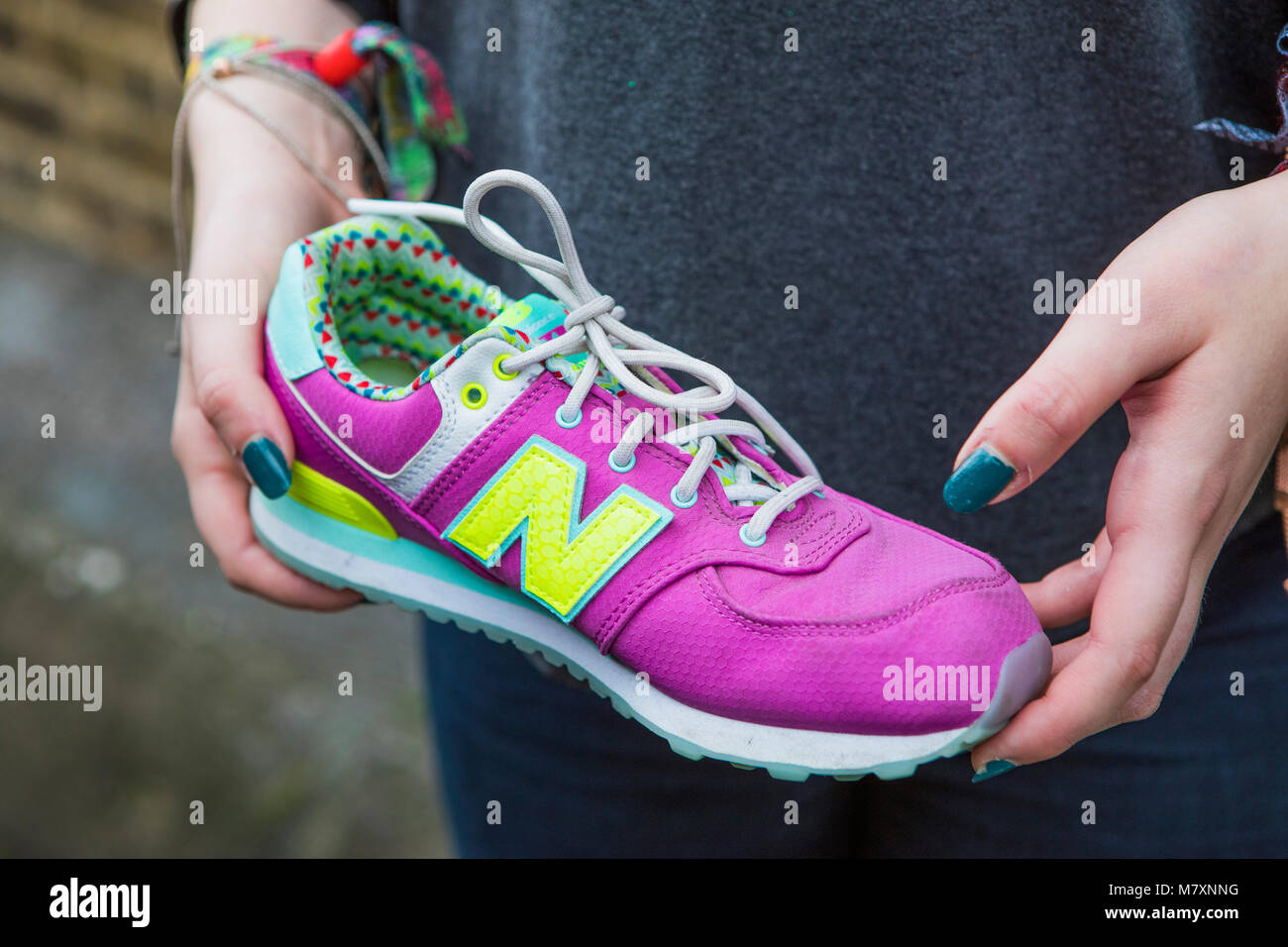 Cool vintage rosa Nike trainer detenute da una donna. Foto Stock