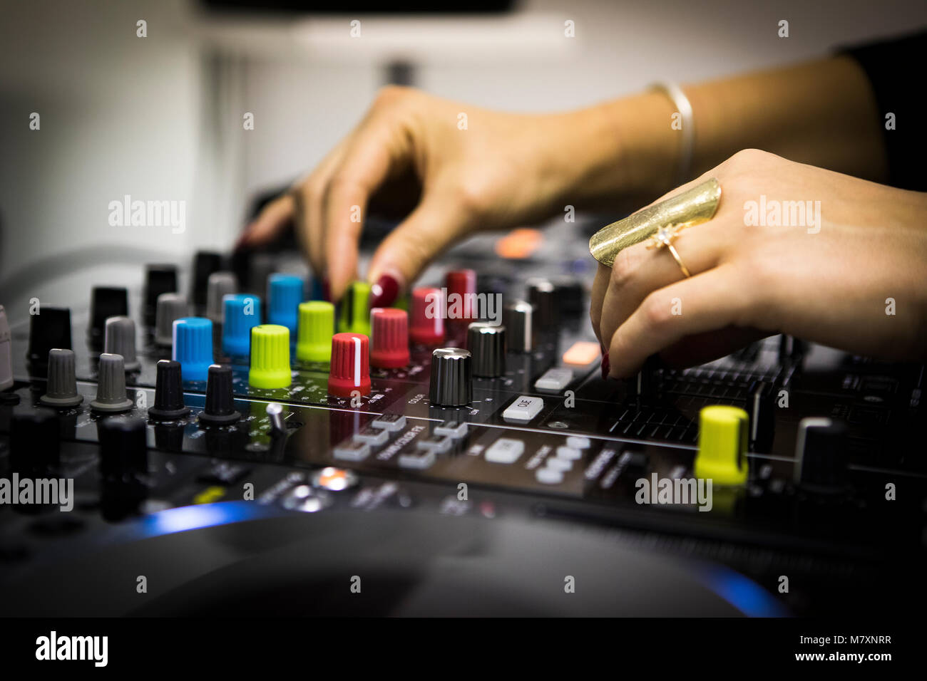 DJ femmina con le unghie rosse su CDJ e mixer. Foto Stock