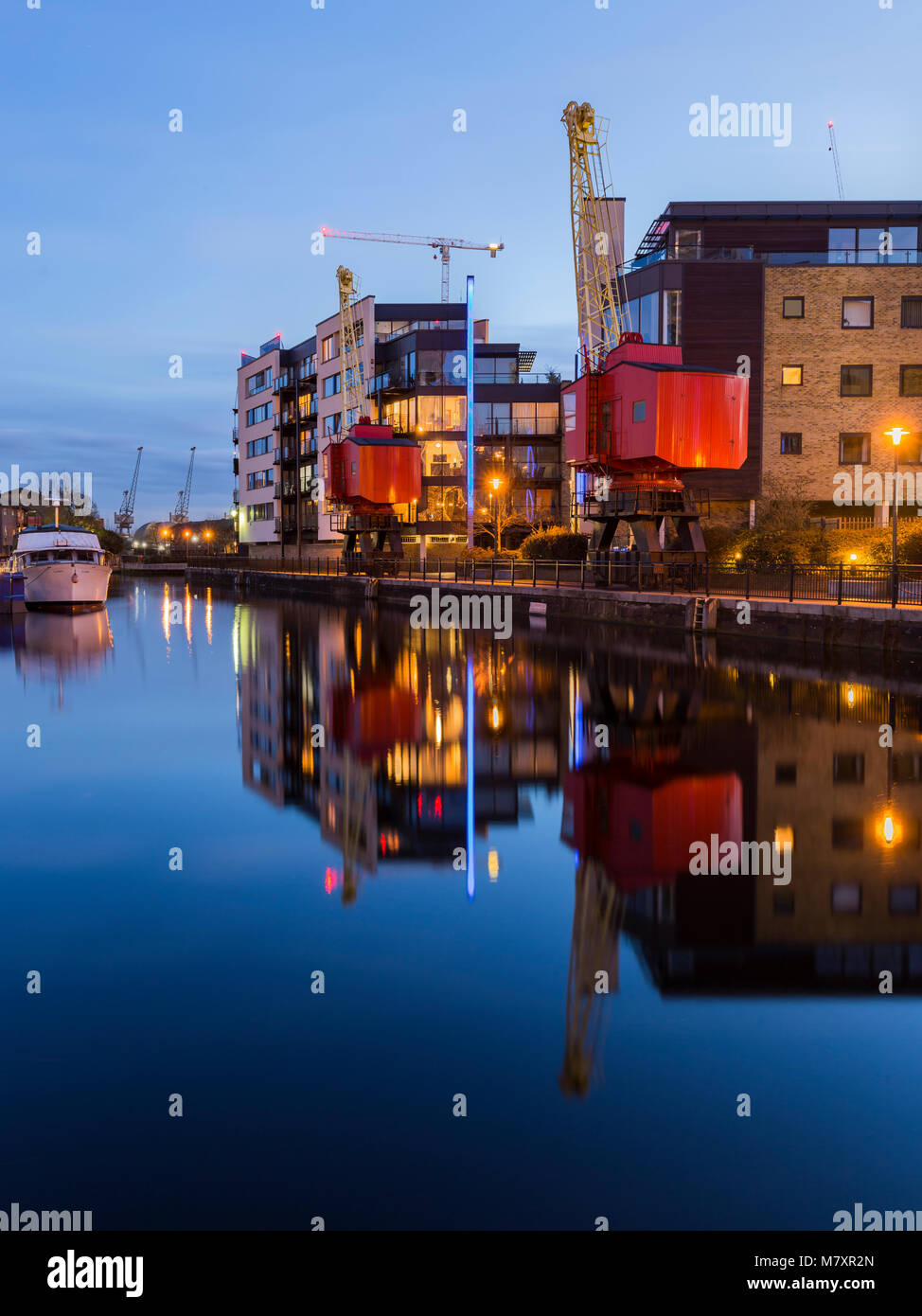 LONDON, Regno Unito - MAR 2018: il lungofiume di moderni edifici con le vecchie dockland gru Foto Stock