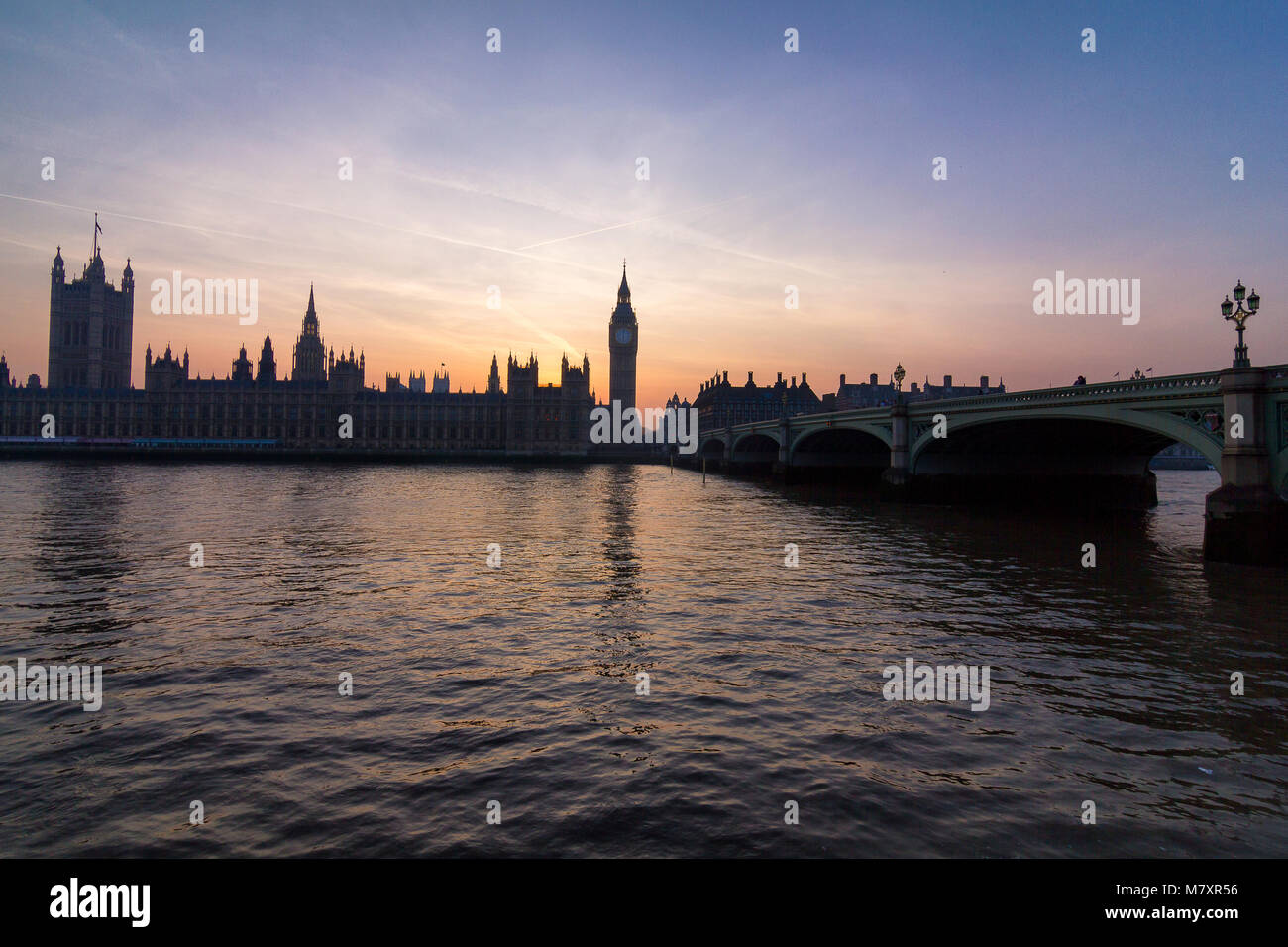 Londra, UK: il parlamento di Westminster con Thames in primo piano al tramonto Foto Stock