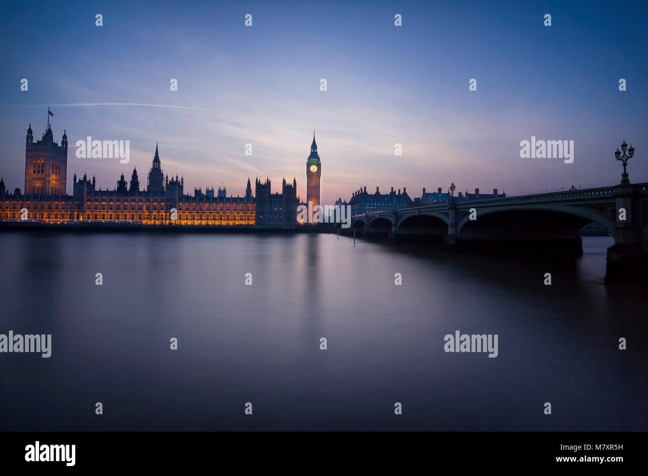 Londra, UK: il parlamento di Westminster con Thames in primo piano dopo il tramonto Foto Stock