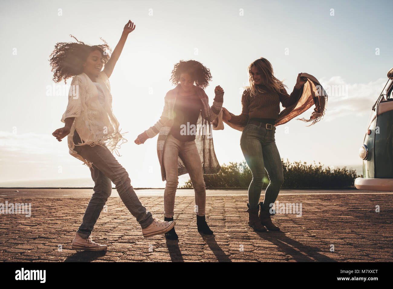 Amici di sesso femminile che danzano sulla strada. Il gruppo di donne godendo una giornata di viaggio. Foto Stock