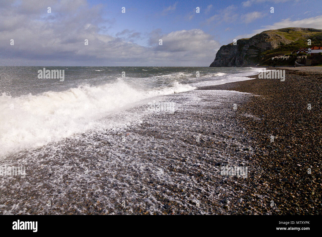 Spray e di onde sulla sponda nord Pebble Beach, Llandudno, costa del Galles Settentrionale Foto Stock