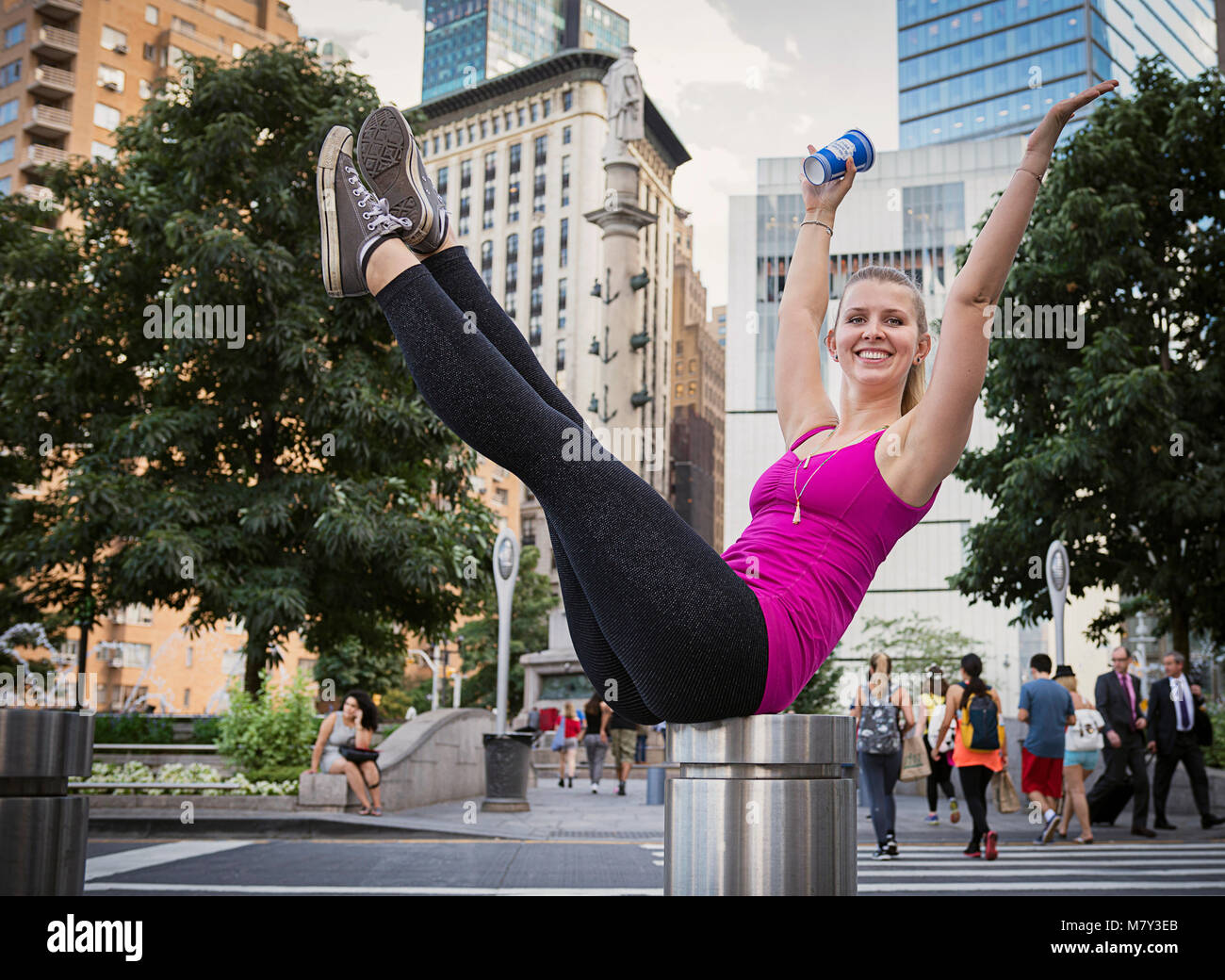 Una donna facendo un Pilates teaser a Columbus Circle, NYC Foto Stock