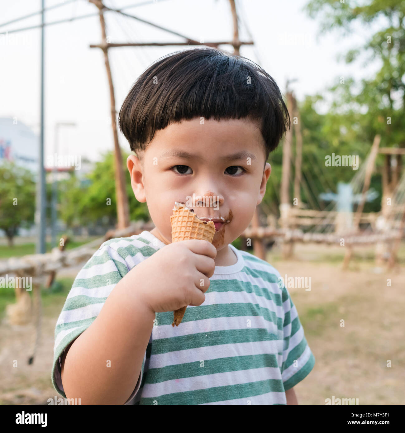 Capretto felice ragazzo a mangiare il gelato nel parco Foto Stock