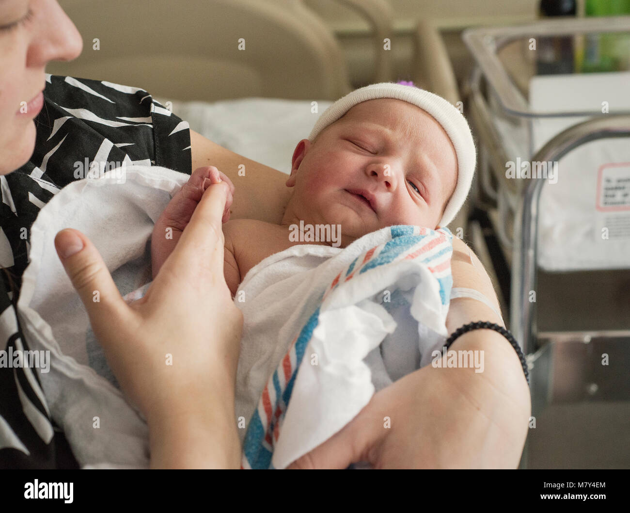 Un neonato essendo trattenuto in ospedale dalla sua madre il giorno in cui è nato. Foto Stock