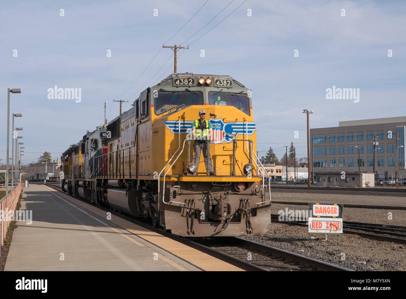 Pacific Unione locomotori passando dalla piattaforma nelle stazioni di smistamento di Roseville California. Ingegnere di sicurezza a cavallo su una piattaforma sul piombo loco Foto Stock