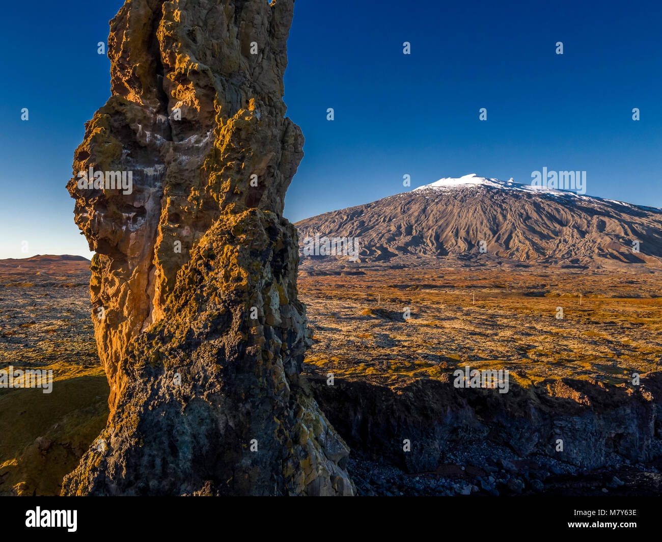 Mare Londrangar pile-basalto vulcanico, dighe in distanza, ghiacciaio Snaefellsjokull, Snaefellsnes Peninsula, Western Islanda. Foto Stock