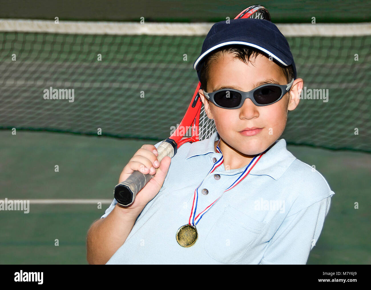 Ragazzino con un cappello e occhiali da sole in posa dopo una notte  vincente partita di tennis Foto stock - Alamy