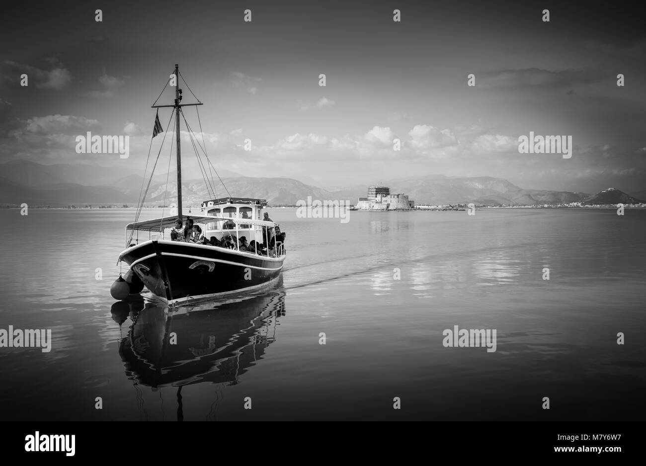 Nafplio,Bourtzi, Grecia - 27 dicembre 2015: le barche con i turisti,navigazione in acque tranquille del Golfo Argolic, Grecia. Sunray riflettere attraverso blue gree Foto Stock