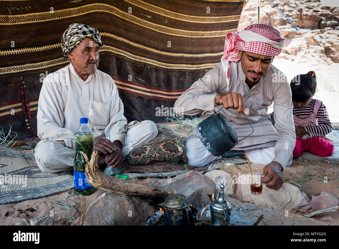 Due uomini di bere chai e rilassante nella loro tenda beduina nel Wadi Rum in Giordania. Foto Stock