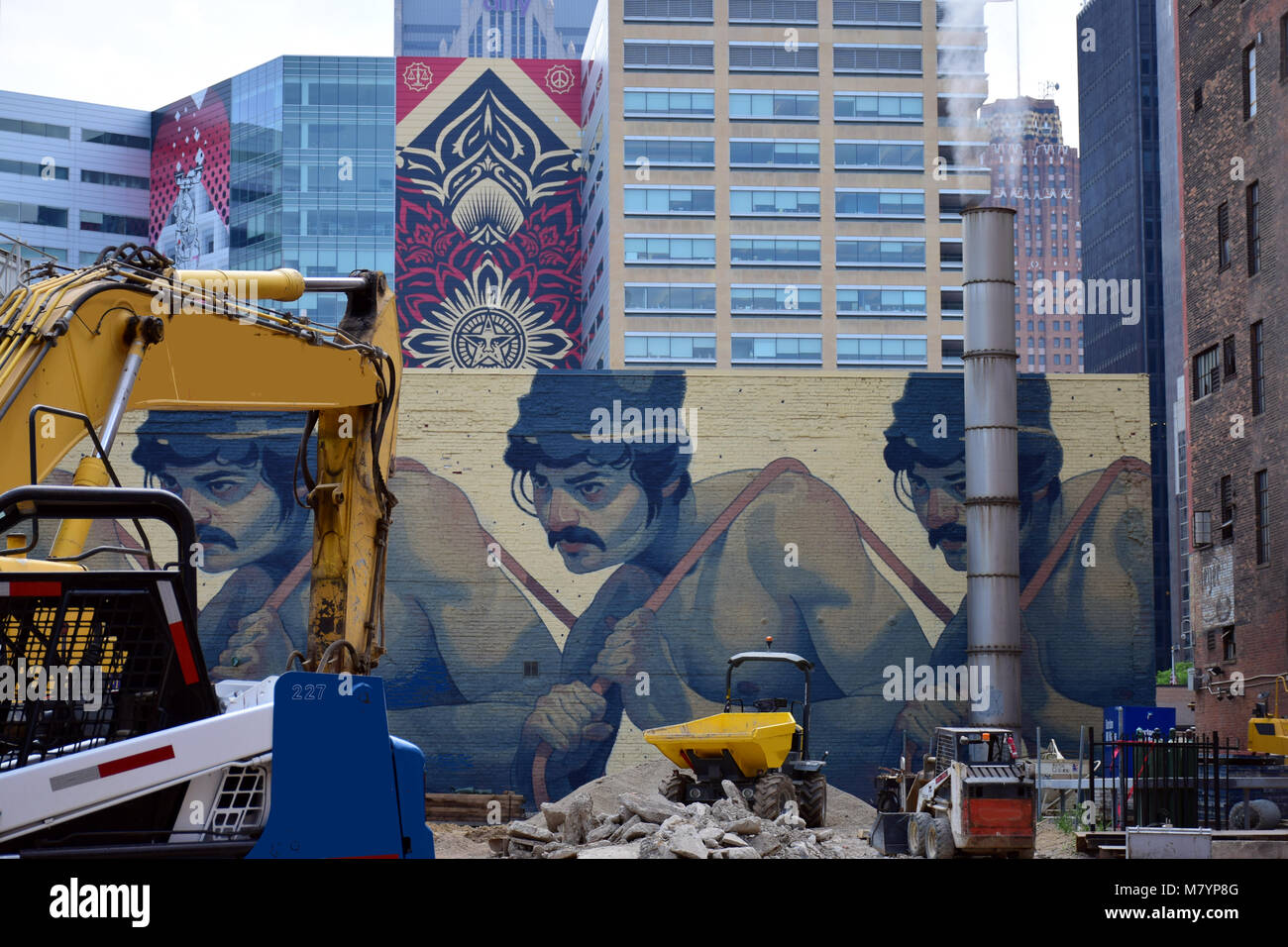 Un sito in costruzione nel centro di Detroit, USA, con edifici di uffici e arte di strada in background Foto Stock