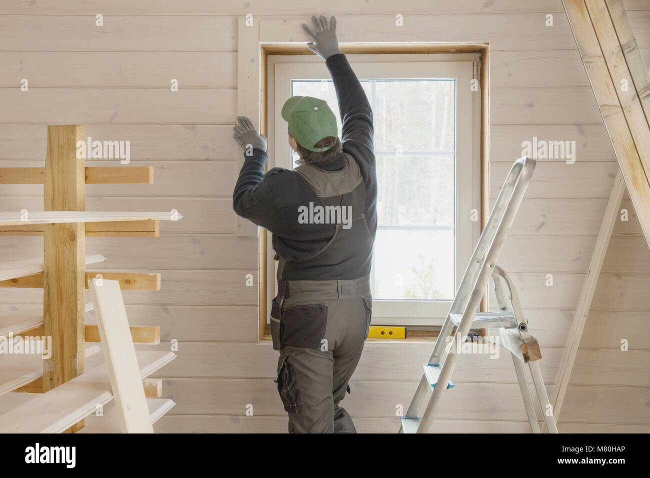 Operaio edile isolante termicamente eco telaio in legno casa con la fibra di legno piastre. La finitura del soffitto con un bianco tavola di legno. Lettonia Foto Stock