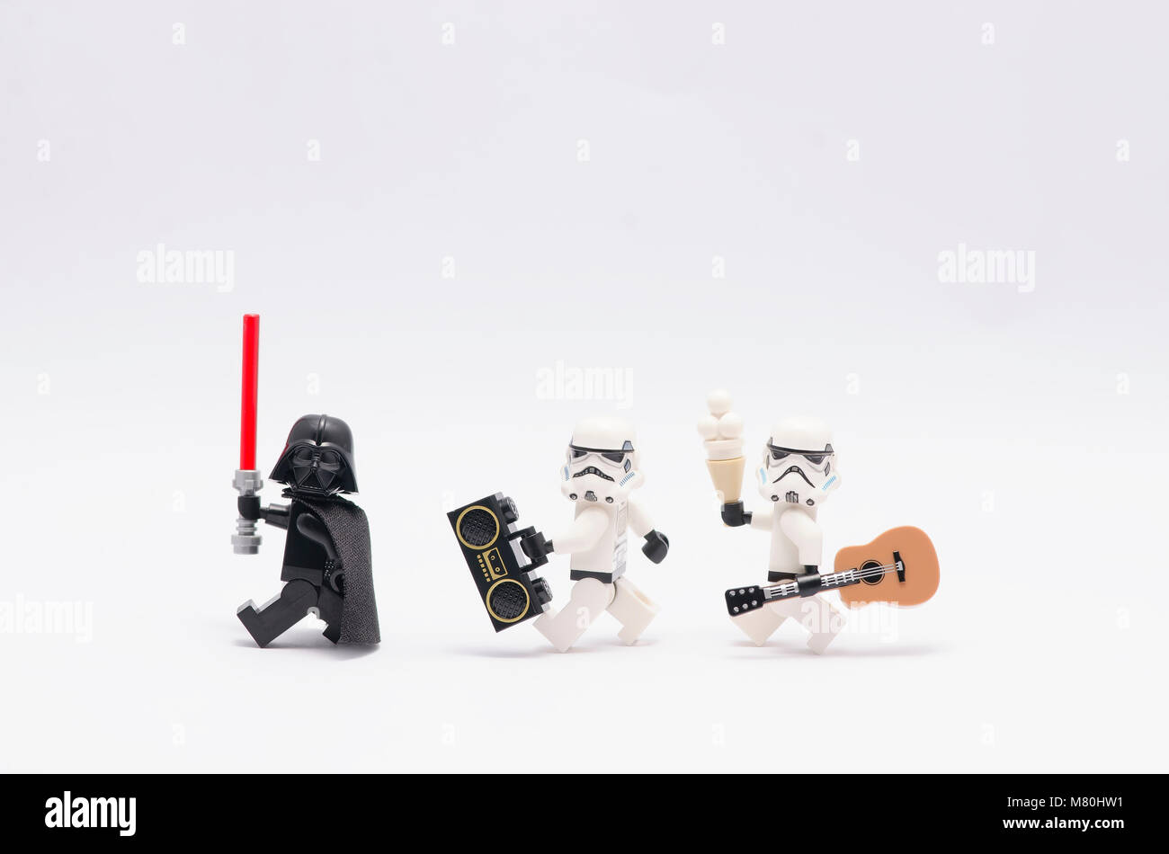 Lego Darth Vader azienda light saber con storm troopers tenendo un radio e una chitarra. isolato su sfondo bianco. Foto Stock