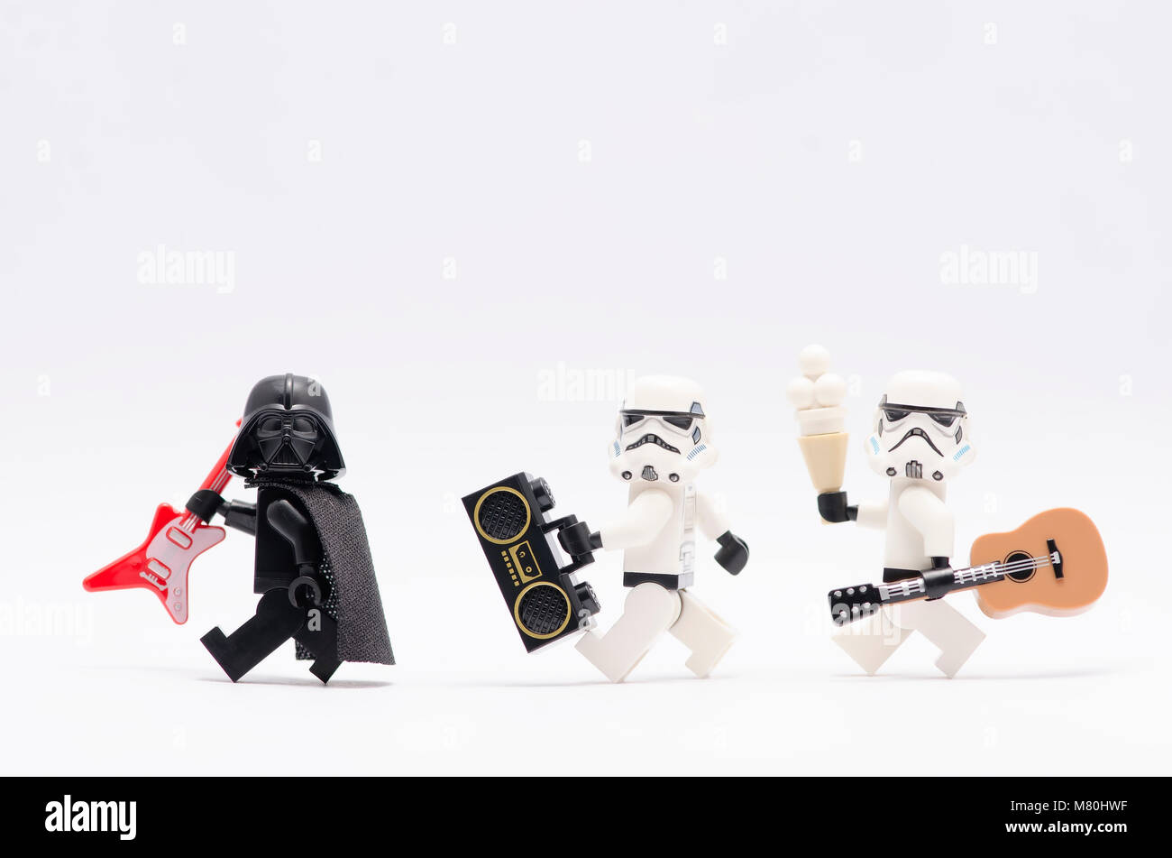 Lego Darth Vader tenendo la chitarra con storm troopers tenendo un radio e una chitarra. isolato su sfondo bianco. Foto Stock