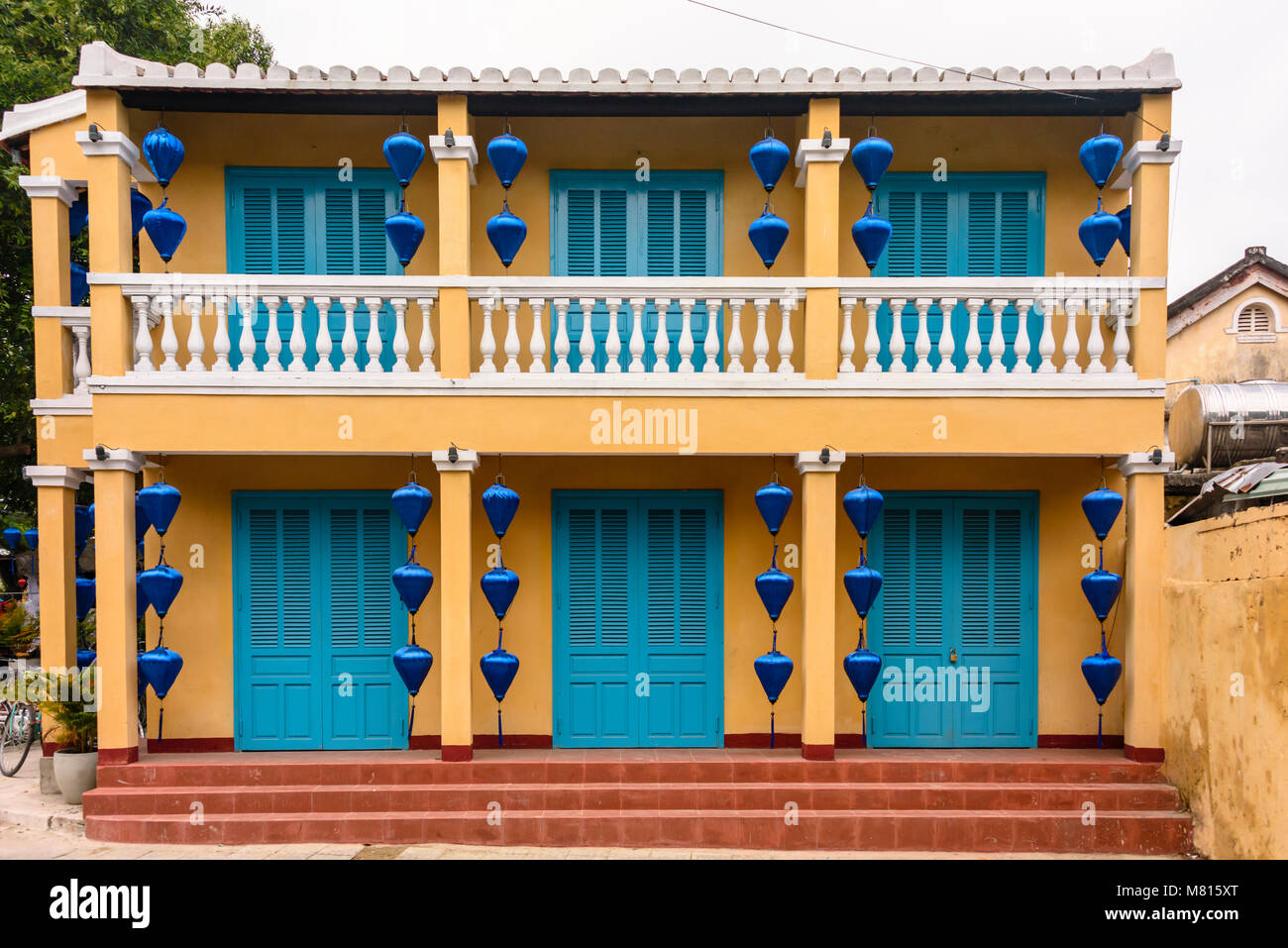 Un giallo e blu di edificio con lanterne blu in Hoi An, Vietnam Foto Stock