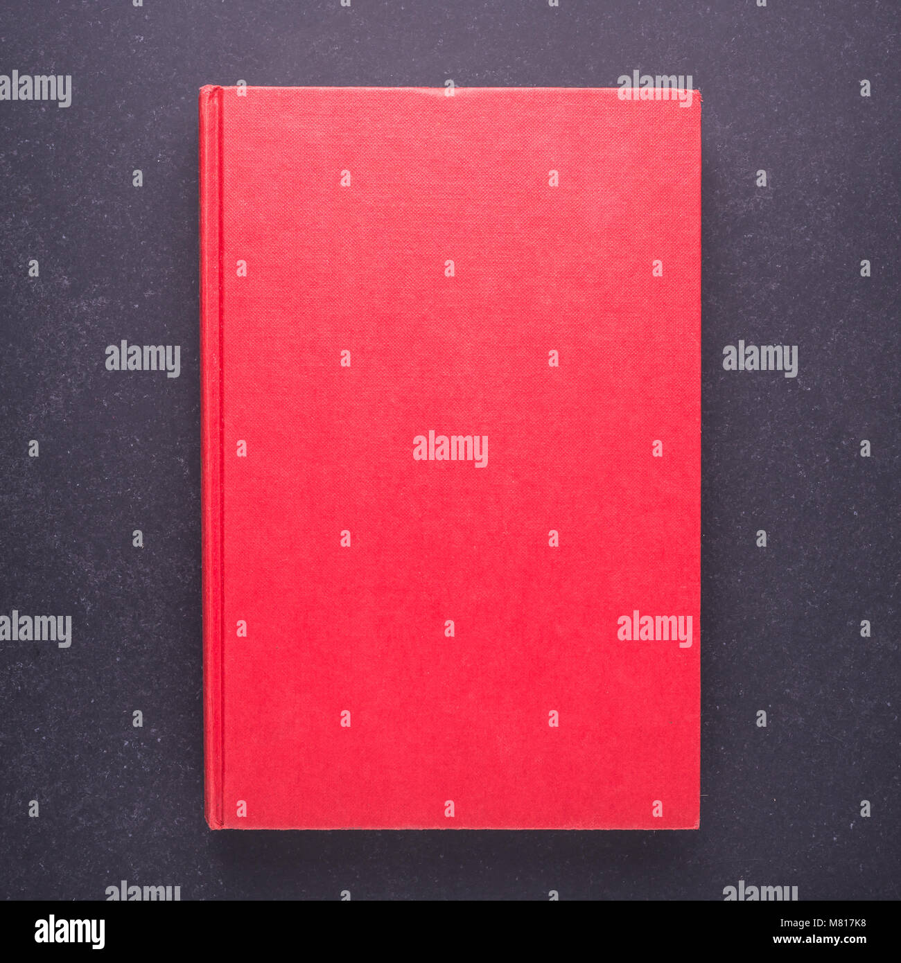 Libro rosso con vuoto vuoto sul coperchio di pietra nera di sfondo della tabella. Vista superiore Foto Stock