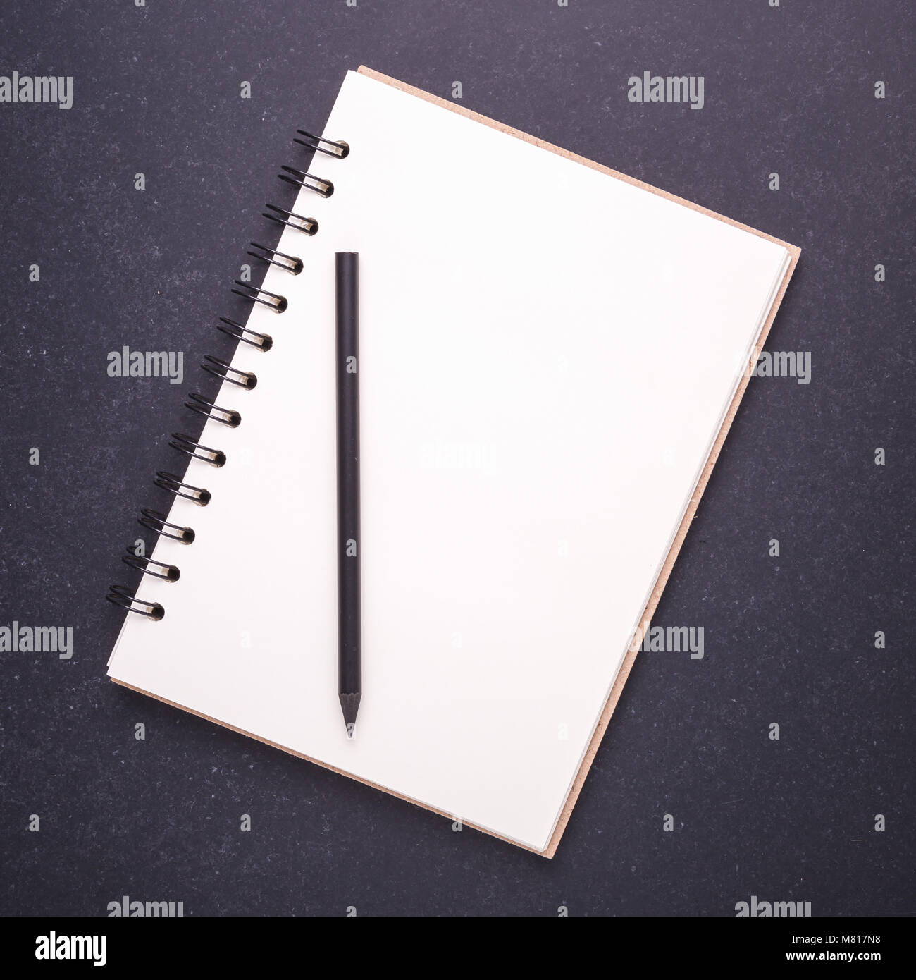 Nuovo notebook con vuoto vuoto sul coperchio di pietra nera di sfondo della tabella. Vista superiore Foto Stock