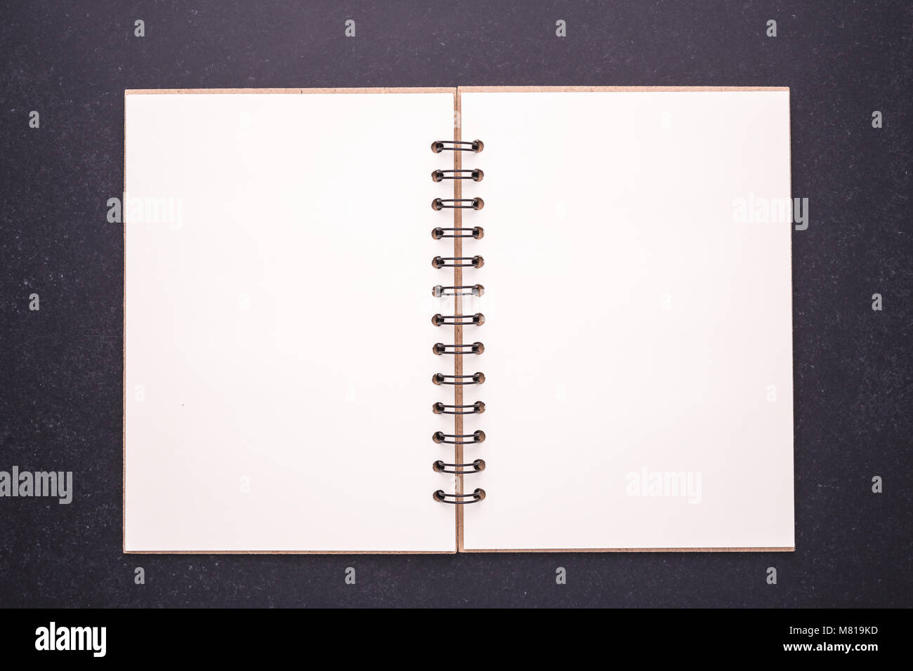 Nuovo notebook con vuoto vuoto sul coperchio di pietra nera di sfondo della tabella. Vista superiore Foto Stock