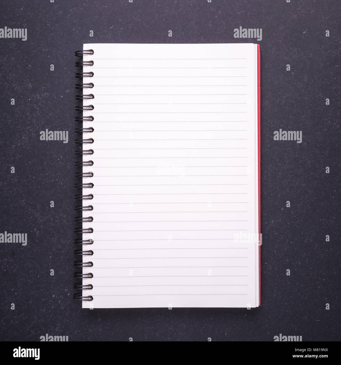 Nuovo notebook con vuoto vuoto sul coperchio di pietra nera di sfondo della tabella. Vista superiore Foto Stock