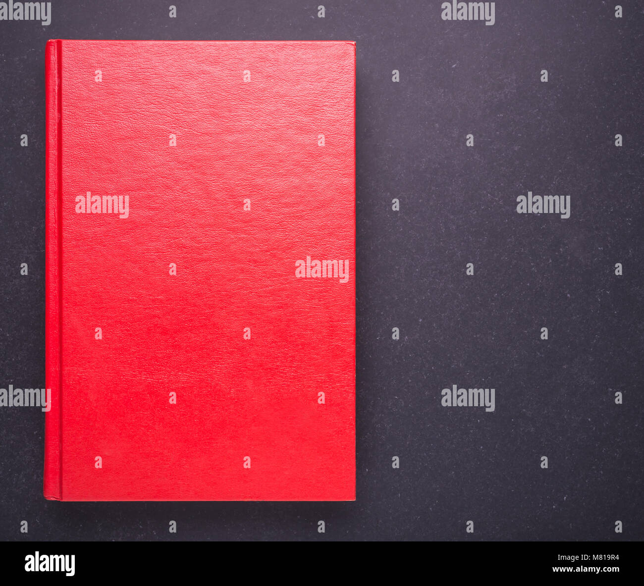 Libro rosso con vuoto vuoto sul coperchio di pietra nera di sfondo della tabella. Vista superiore Foto Stock