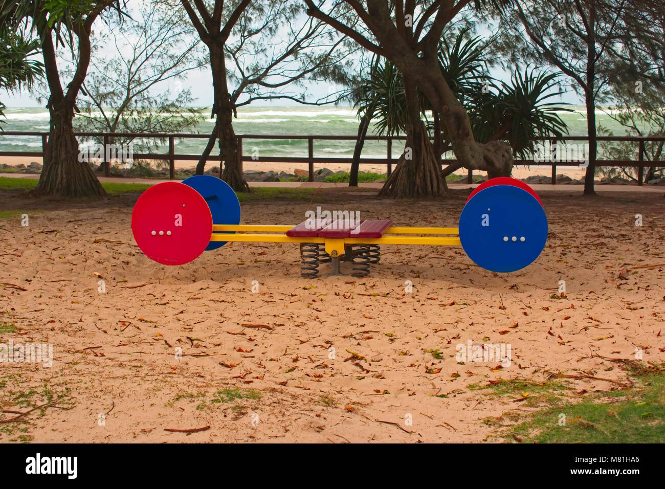 Swing su un parco giochi dall'oceano Foto Stock