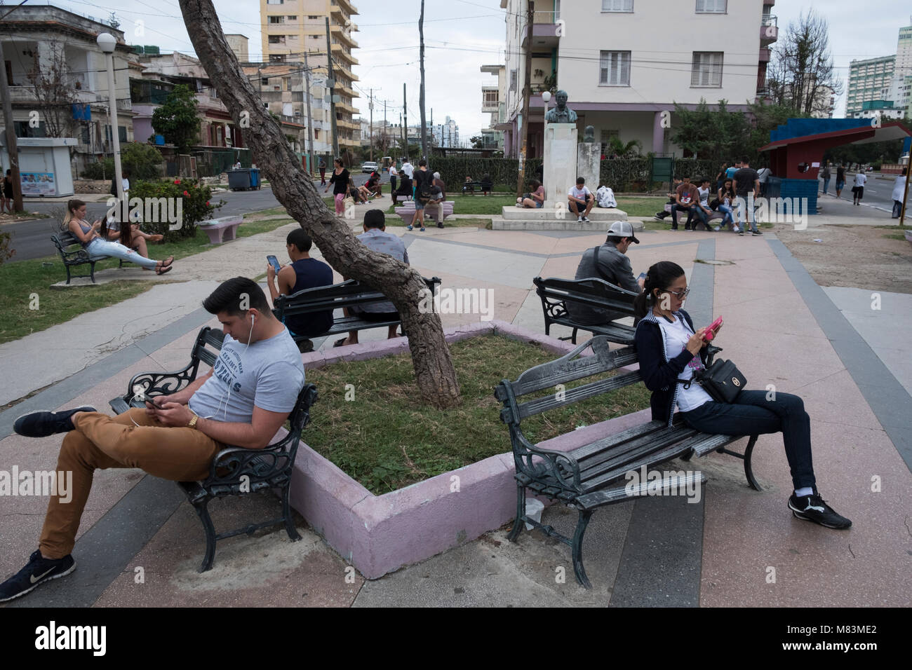 Persone che utilizzano la connessione internet wi-fi alla pubblica piazza, Havana, Cuba Foto Stock