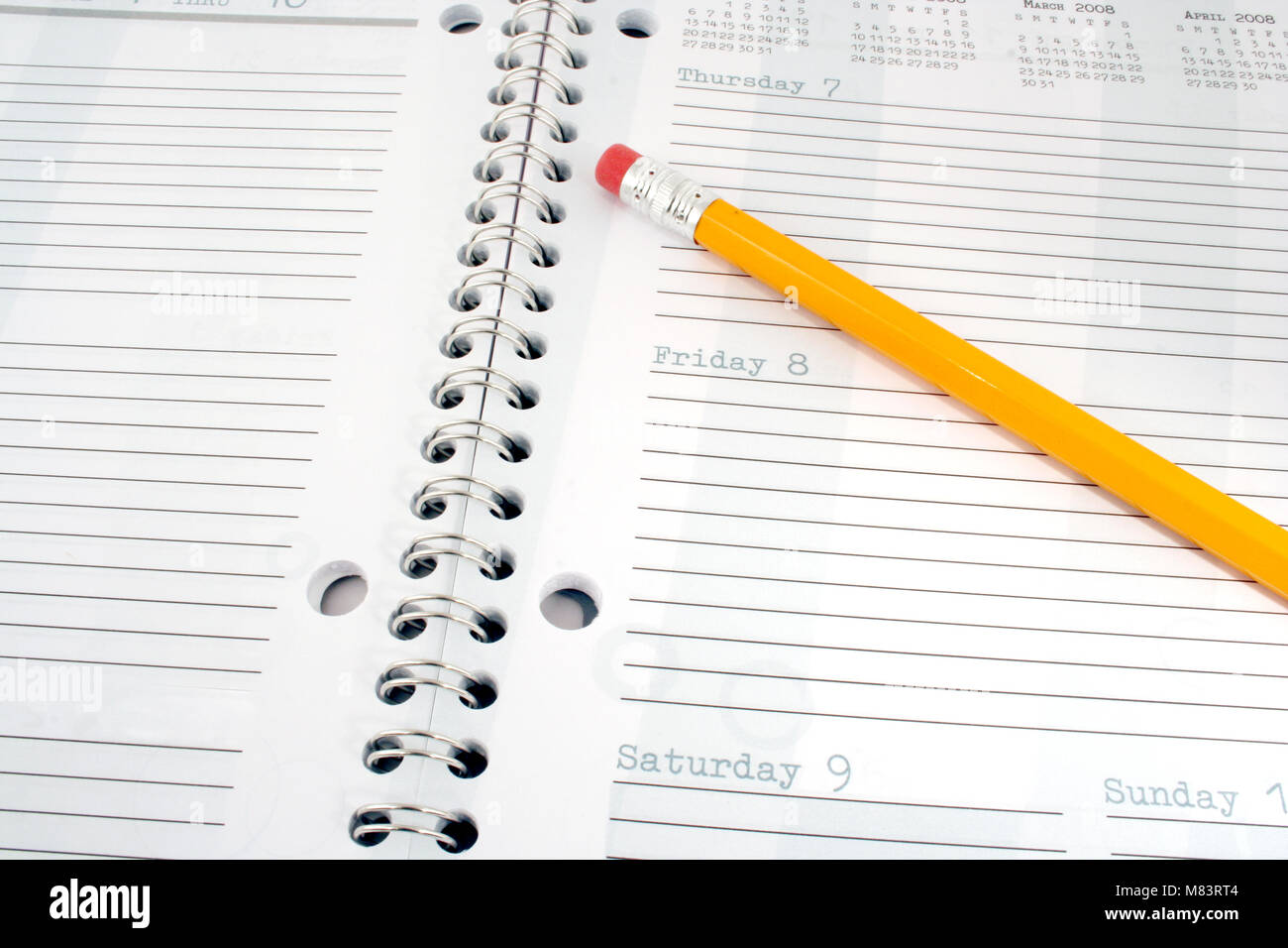 Una matita gialla su un pianificatore di giorno Foto Stock