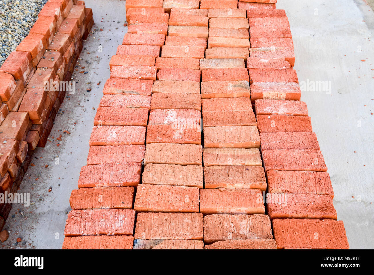 Il rosso mattone piegate ordinatamente sulla fondazione della casa. Costruzione in casa Foto Stock