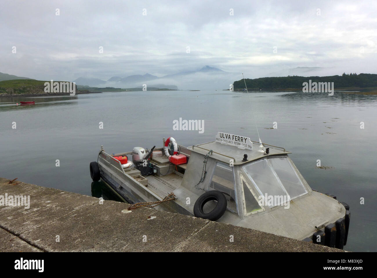 Il piccolo traghetto sul dock sul isola di Ulva. Esso traghetti tra Ulva e Mull. Foto Stock