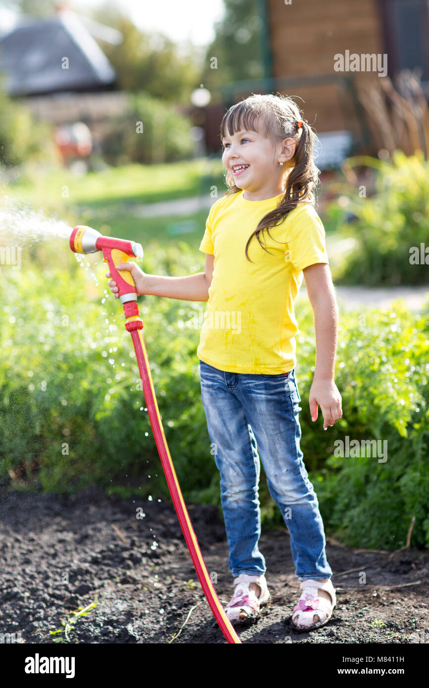 Carino il toddler girl divertendo tanto acquolina in giardino. Foto Stock