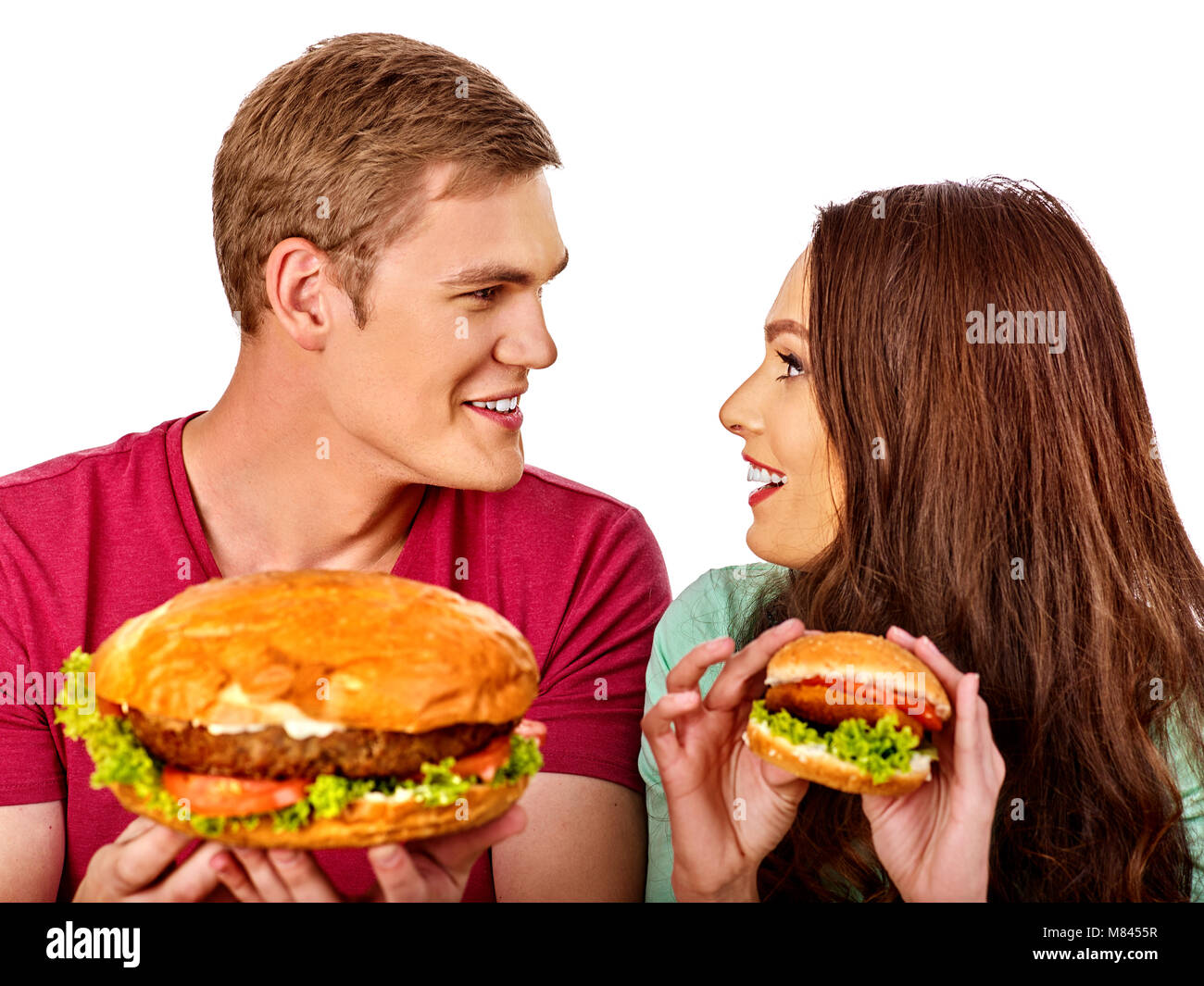 Paio di mangiare fast food. L uomo e la donna a mangiare hamburger con prosciutto. Foto Stock