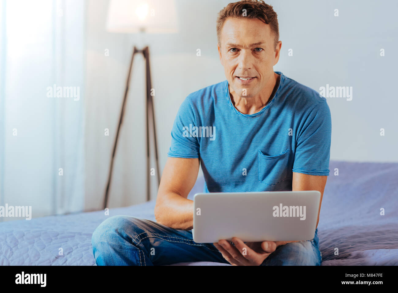 Positivo uomo bello tenendo un netbook Foto Stock