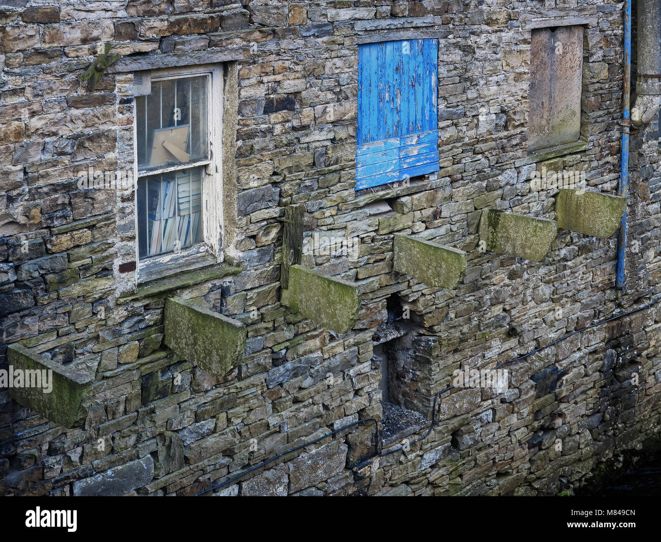 Il lato di un edificio in pietra adiacente a Gayle Beck Foto Stock
