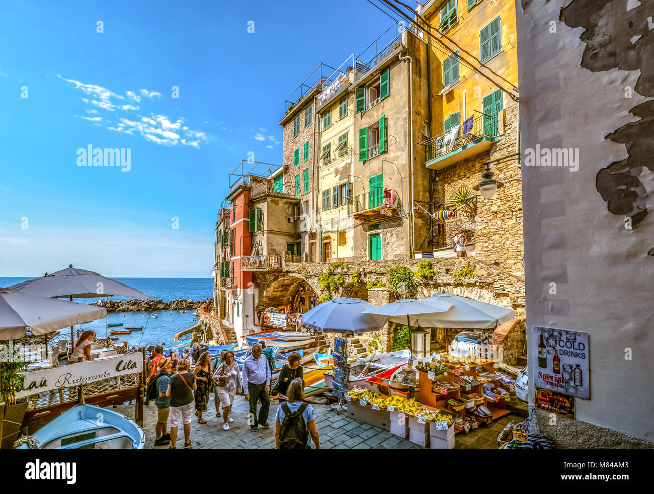 Il turista a godere di una mattina di sole a inizio autunno come essi a  piedi passato un mercato e caffè presso il porto di Riomaggiore Cinque Terre  Italia Foto stock -